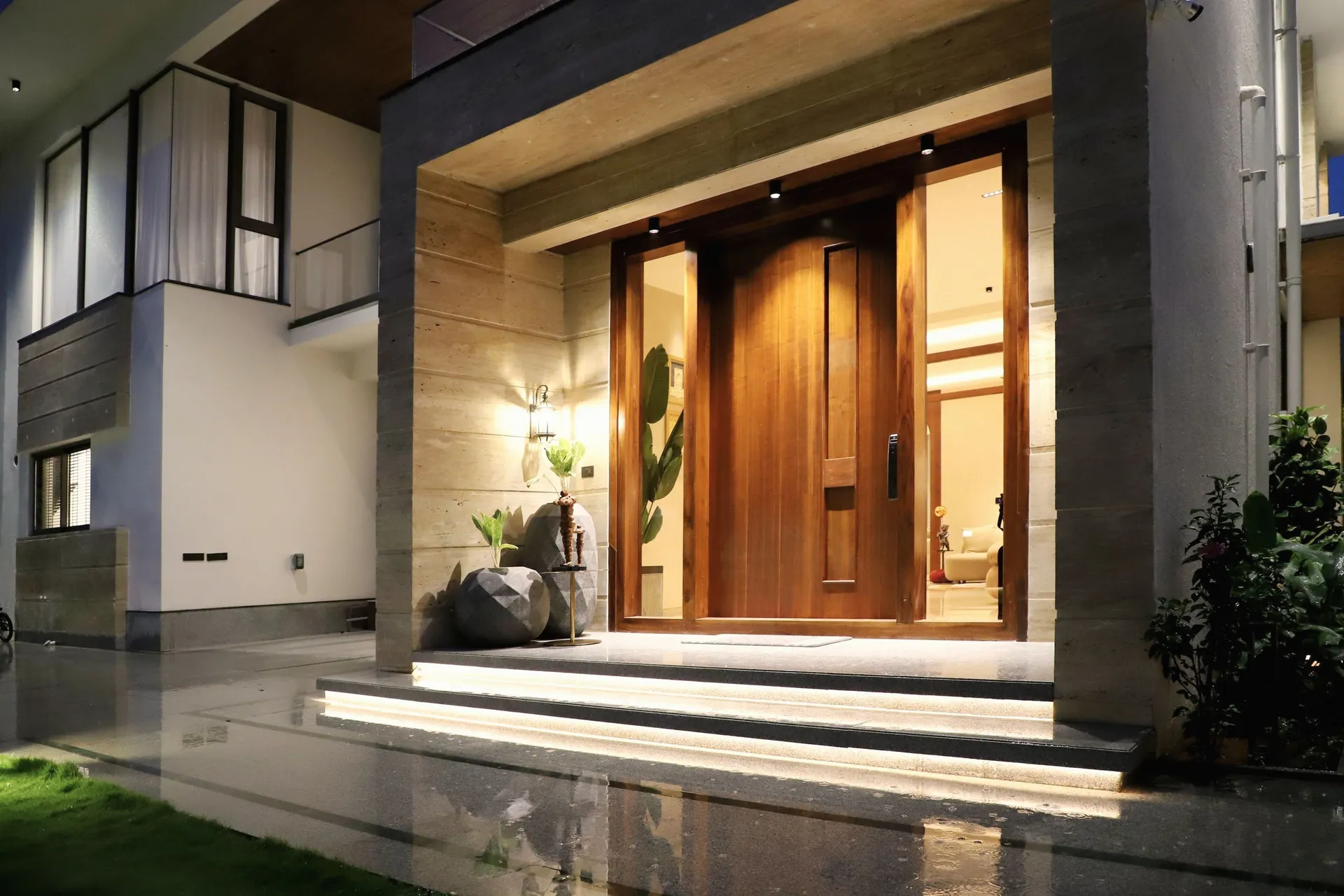 Akşam ışığında ahşap kaplamalı pivot villa giriş kapısı